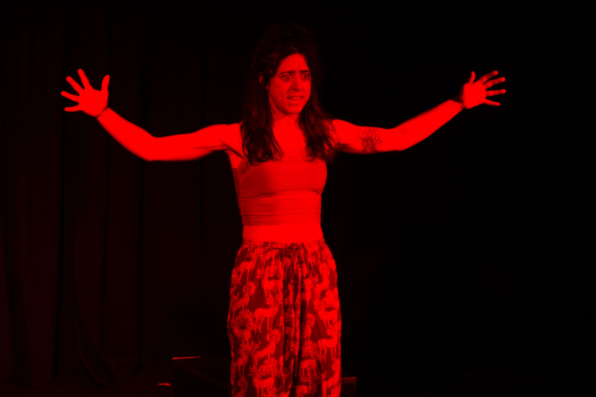 Emma looking frantic in a deep red light